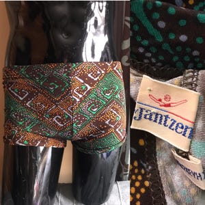 May include: Brown and green patterned swimming trunks with a white label that says "Jantzen" with a swimmer logo.