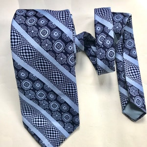 Psychedelic, groovy, novelty printed late 60s/early 70s vintage “bell” Trevira necktie in ice blue and black by Resilio. Amazing cravate
