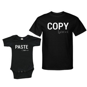 May include: Black t-shirt with the word "COPY" and a computer mouse cursor with the text "Ctrl + C" underneath. A black baby onesie with the word "PASTE" and a computer mouse hand with the text "Ctrl + V" underneath.