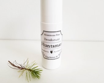 May include: White deodorant stick with a black label that says "Aluminum Free Deodorant Huntsman Apothecary Dewberry 2.1 oz Charleston, SC". The label has a small strawberry graphic.