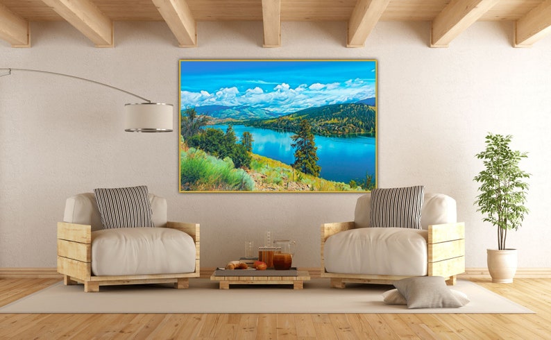 Puede incluir: Una pintura de paisaje enmarcada que representa un lago rodeado de monta&ntilde;as y &aacute;rboles. El lago es de un azul vibrante, y el cielo es de un azul brillante con nubes blancas. Las monta&ntilde;as son de un verde y marr&oacute;n suave, y los &aacute;rboles son de un verde intenso.