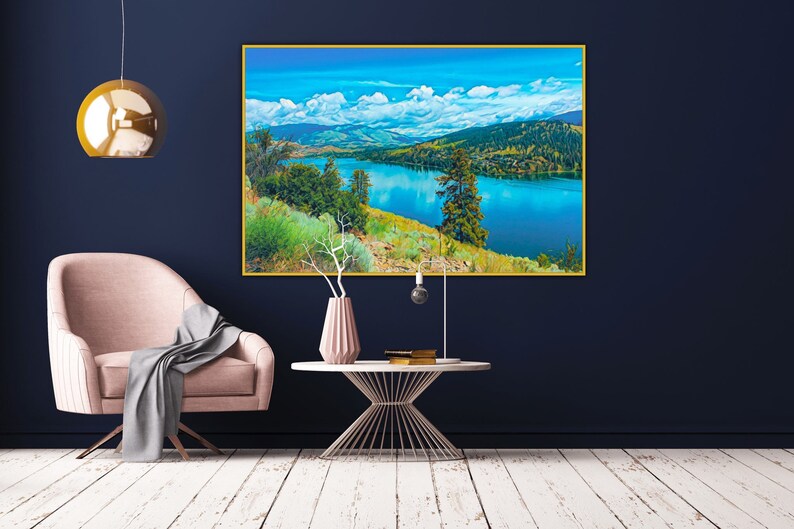 Puede incluir: Una fotograf&iacute;a de paisaje enmarcada de un lago rodeado de monta&ntilde;as y &aacute;rboles. El lago es de un azul vibrante y el cielo es de un azul claro con nubes blancas. Las monta&ntilde;as son de un verde oscuro y los &aacute;rboles son de un verde claro.