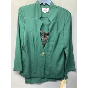 May include: A solid dark green blazer with long sleeves, a single gold-tone button closure, and a notched collar. The blazer features a visible inner layer with a dark green and orange textured floral pattern. A Caron brand label is at the neck.