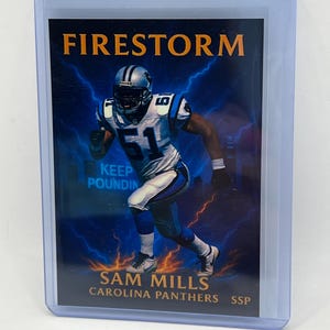 May include: A football trading card featuring Sam Mills of the Carolina Panthers. The card has a blue and white color scheme with the word "Firestorm" at the top. The text "Keep Pounding" is also visible.