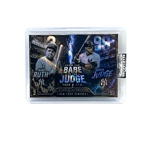 May include: A baseball trading card featuring Babe Ruth and Aaron Judge. The card has a holographic design with the text "From the Babe to the Judge" and "Legends of the Pinstripes". The card is encased in a clear protective holder.