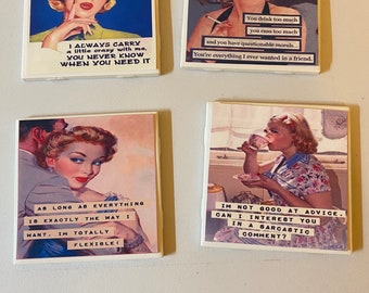 Puede incluir: Cuatro posavasos de estilo vintage con frases humorísticas e imágenes de mujeres de la década de 1950. Los posavasos son blancos con un acabado brillante. Las frases en los posavasos son: "Siempre llevo un poco de locura conmigo, nunca se sabe cuándo la necesitarás", "Bebes demasiado, blasfemas demasiado y tienes una moral cuestionable... Eres todo lo que siempre quise en un amigo", "Mientras todo esté exactamente como yo quiero, soy totalmente flexible!" y "No soy bueno dando consejos. ¿Puedo interesarte en un comentario sarcástico?"
