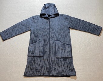 May include: A long, dark blue quilted hooded robe with two patch pockets. The robe has a zipper closure and a textured quilted pattern.