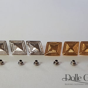 May include: Six metal diamond-shaped buttons, three silver and three gold, with a textured surface.  The buttons are arranged in two rows of three.  Below the buttons are six silver eyelets.  The image also includes the text "Dolle Griet BESPOKE CLOTHING AND COSTUMES".