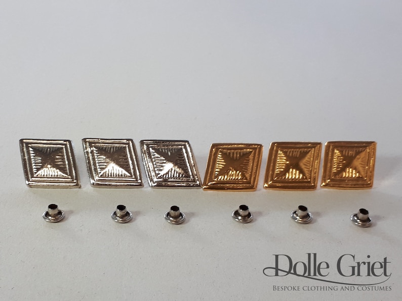 May include: Six metal diamond-shaped buttons, three silver and three gold, with a textured surface.  The buttons are arranged in two rows of three.  Below the buttons are six silver eyelets.  The image also includes the text "Dolle Griet BESPOKE CLOTHING AND COSTUMES".