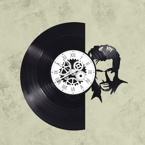 May include: A black vinyl record clock with a white clock face and gears. The clock face has Roman numerals and the gears are around the clock face. The clock is mounted on a wall with a silhouette of a man's face on the right side of the clock.