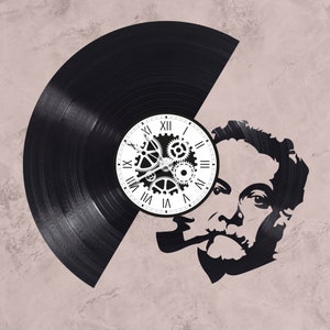 May include: A black vinyl record clock with a white face and gears. The clock is partially obscured by a black and white silhouette of a man's face.