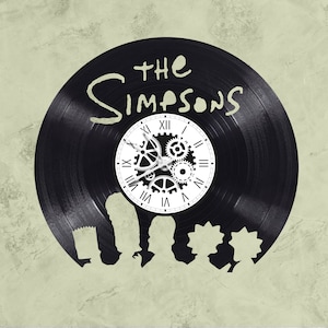 May include: Black vinyl record clock featuring the Simpsons characters with a clock face in the center that says "The Simpsons".