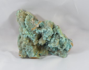 May include: A cluster of green and white mineral specimens with a rough, textured surface. The mineral has a bubbly, rounded appearance.