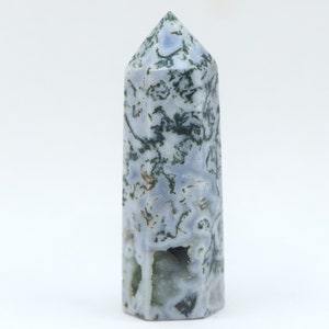 May include: A tall, hexagonal-shaped crystal point with a polished finish. The stone features a mix of pale blue, white, and green colors, with a pattern of moss-like inclusions. The top is a pointed apex. A natural gemstone for display.