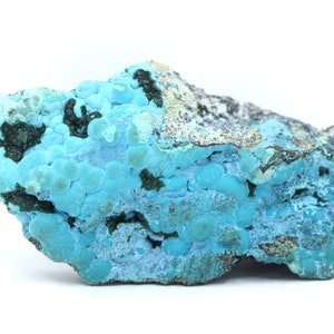 May include: A blue and green mineral specimen with a rough, textured surface. The mineral has a distinctive, bubbly appearance.