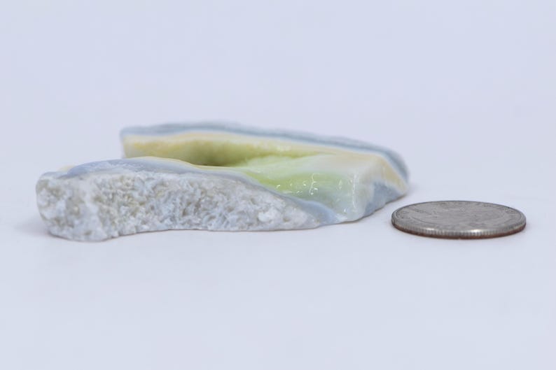 Pu&ograve; includere: Una pietra di agata di colore blu chiaro, verde e bianco con una texture ruvida e naturale. La pietra &egrave; circa delle dimensioni di una moneta da 20 centesimi di euro.