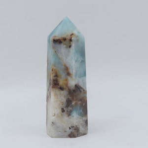 May include: A blue, white, and brown crystal point with a pointed top and a flat base.