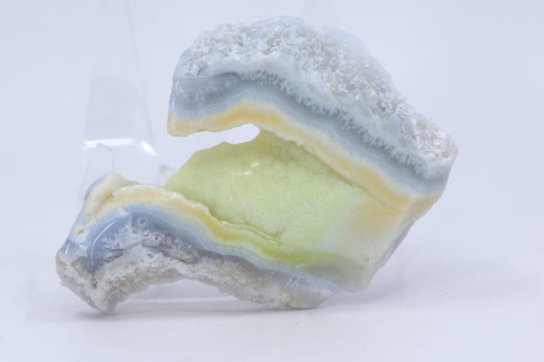 Pu&ograve; includere: Un'agata blu chiaro, gialla e verde con un motivo unico a strati. L'agata ha una texture ruvida e naturale ed &egrave; un bellissimo esempio di questo tipo di pietra preziosa.