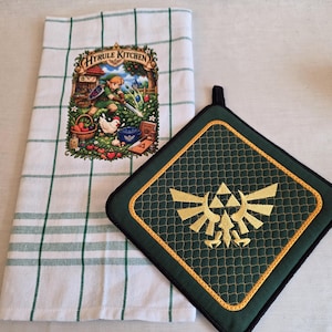 Peut inclure: Un torchon de cuisine blanc à motif quadrillé vert avec une illustration colorée Hyrule Kitchen et un manique carré vert foncé avec un emblème Triforce brodé en jaune et une boucle de suspension noire, inspirés par le jeu vidéo.
