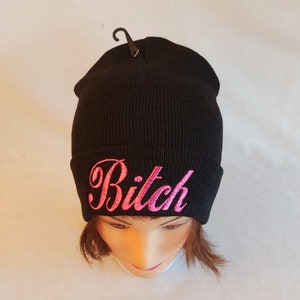 Könnte beinhalten: Schwarze Mütze mit pinkfarbenem Stickerei-Text "Bitch".