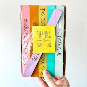 May include: Set of six colorful wooden bookmarks with different phrases, including "Thanks a Million", "On Vacation", "Be Kind", "In a meeting", "Once call", and "In another campus".