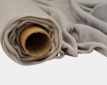 May include: A roll of soft, gray fleece fabric. The fabric is partially unrolled, revealing a brown cardboard core. The fleece has a plush texture and a subtle sheen, suggesting it is new and unused. The fabric is suitable for various sewing and crafting projects.