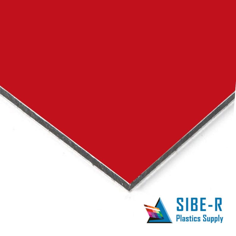 May include: A close-up of a red sheet of aluminium composite material (ACM) panel. The panel has a smooth, flat surface and a black edge.