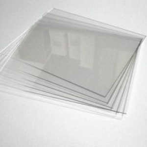 May include: A stack of clear plastic sheets, likely for crafting or protecting surfaces.