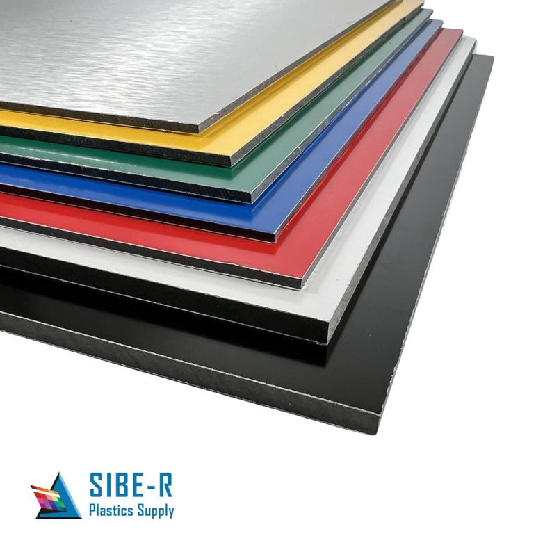 May include: A stack of seven different coloured aluminium composite panels. The panels are arranged from largest to smallest, with the largest panel at the bottom and the smallest panel at the top. The colours of the panels are silver, yellow, green, blue, red, white and black.