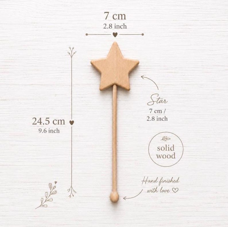 Puede incluir: Una varita de estrella de madera de color marr&oacute;n claro que mide 24,5 cm de longitud total con una parte superior de 7 cm. El texto en la imagen indica que es de madera maciza y est&aacute; acabada a mano. El ancho de la estrella es de 7 cm y la altura es de 24,5 cm.