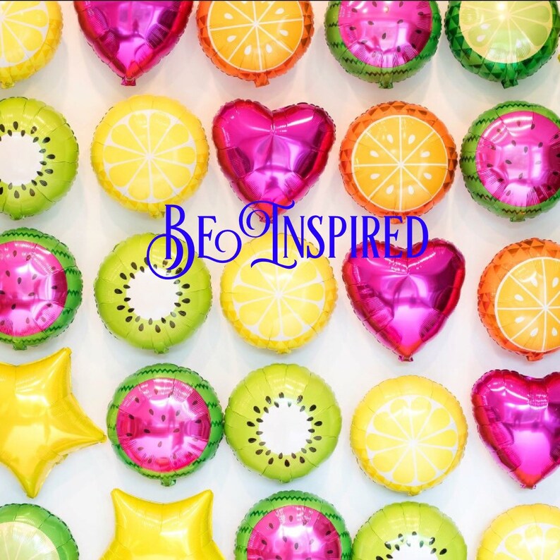 Puede incluir: Una colecci&oacute;n de globos coloridos con forma de fruta, incluyendo limones, kiwis, sand&iacute;as y corazones. Los globos est&aacute;n dispuestos en un patr&oacute;n sobre un fondo blanco. El texto "BE INSPIRED" est&aacute; escrito en letras cursivas negras en el centro de la imagen.