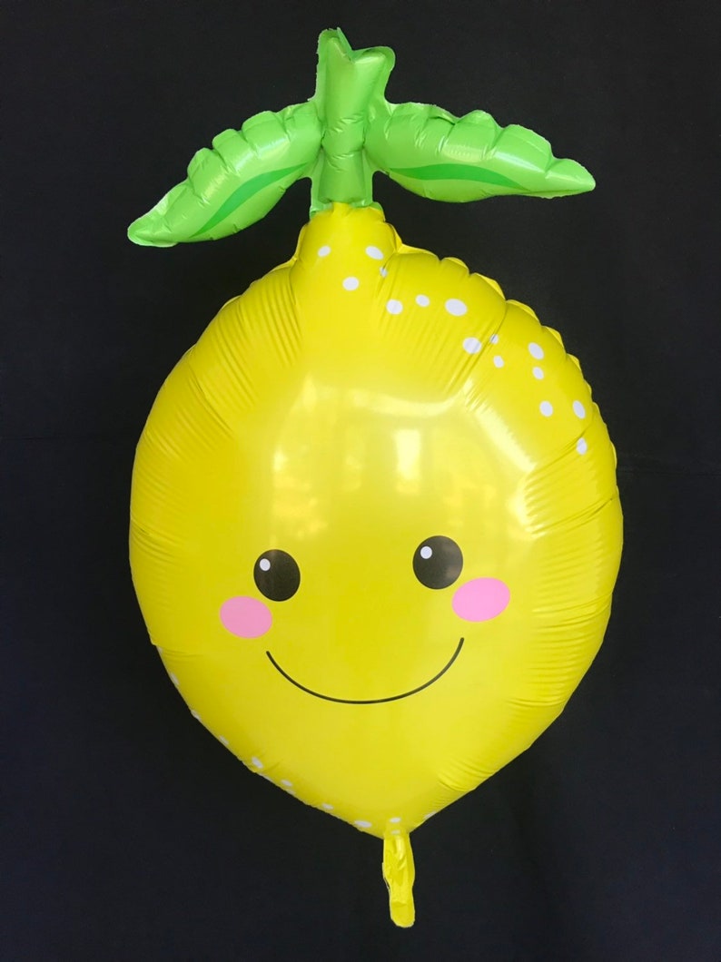 Puede incluir: Un globo amarillo con forma de lim&oacute;n con una hoja verde en la parte superior. El globo tiene un patr&oacute;n de lunares blancos y una cara sonriente con mejillas rosadas.