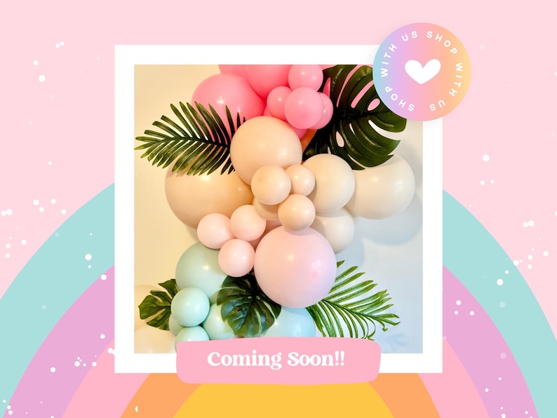 K&ouml;nnte beinhalten: Ein Ballonbogen aus pastellrosa, beige und hellblauen Ballons mit gr&uuml;nen tropischen Bl&auml;ttern. Der Text "Coming Soon!" befindet sich am unteren Rand des Bildes.