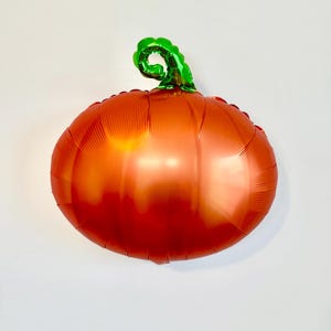 Pu&ograve; includere: Pallone a forma di zucca arancione e verde in lamina.