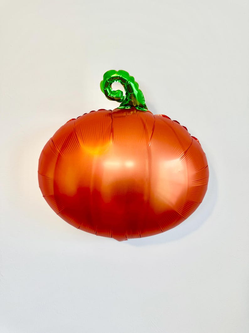 Pu&ograve; includere: Pallone a forma di zucca arancione e verde in lamina.