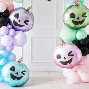 Op de afbeelding: Een Halloween-ballonboog met paarse, blauwe, groene en roze ballons. De boog heeft vier pompoenvormige ballons met knipperende gezichten.