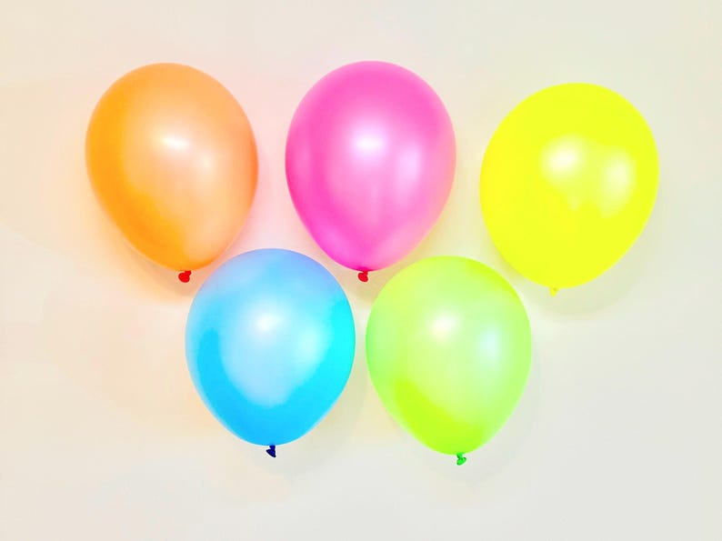May include: Five balloons in different colours: orange, pink, yellow, blue, and green. The balloons are arranged in a semi-circle on a white background.
