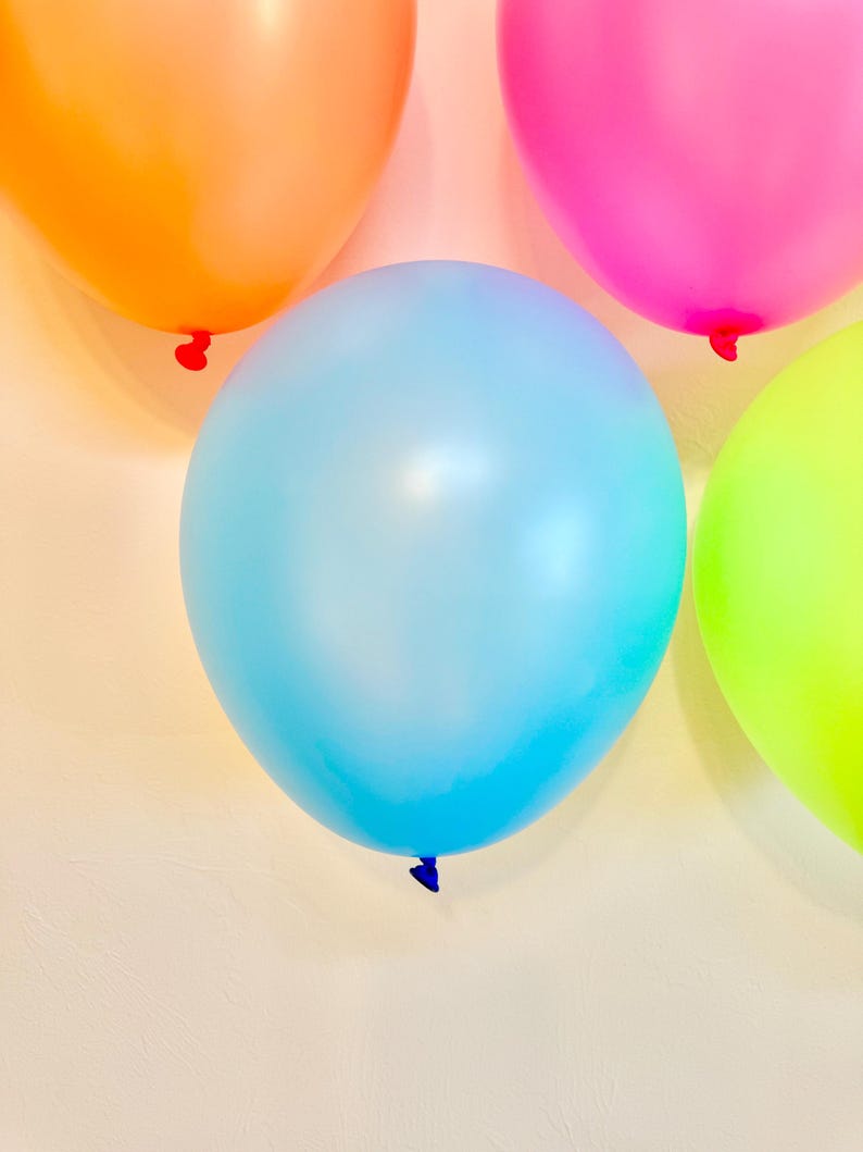 May include: Four balloons in different colours: orange, pink, light blue, and green. The balloons are arranged in a semi-circle on a white background.