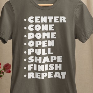 May include: A dark gray t-shirt with white text that reads: "•CENTER •CONE •DOME •OPEN •PULL •SHAPE •FINISH •REPEAT"