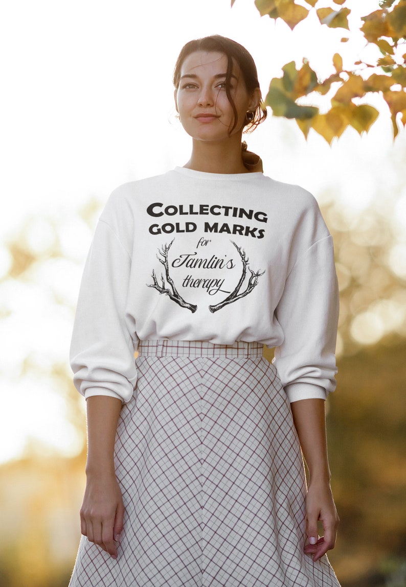 May include: White sweatshirt with black text that reads "COLLECTING GOLD MARKS for Jamlin's therapy" with a black antler graphic.