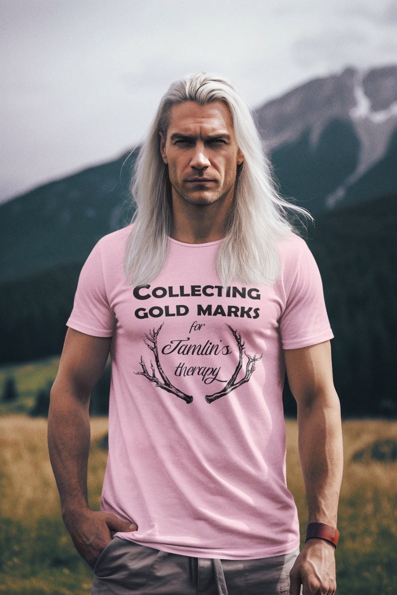 May include: A pink t-shirt with the text "COLLECTING GOLD MARKS for Tamlin's therapy" and a graphic of antlers.