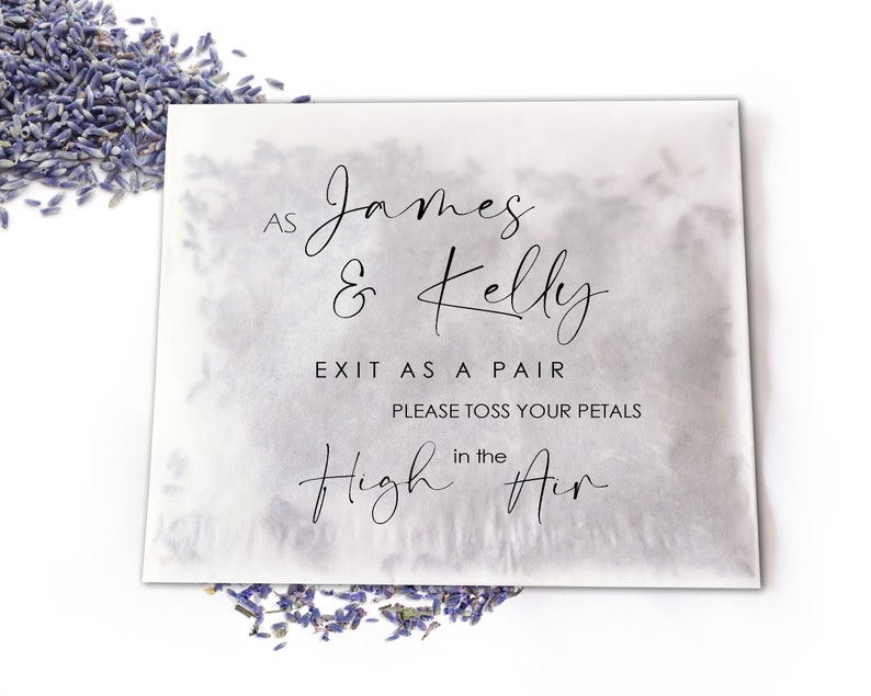 Op de afbeelding: Een wit papieren zakje met de tekst "AS James & Kelly EXIT AS A PAIR PLEASE TOSS YOUR PETALS in the High Air" in zwart script. Gedroogde lavendelbloemknoppen zijn rond het zakje verspreid.