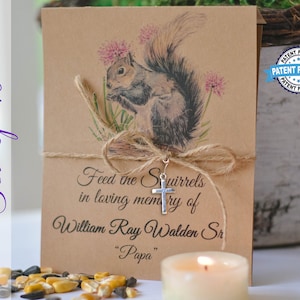 May include: A set of 10 brown paper cards with a squirrel illustration and a small silver cross charm. The cards are tied with twine and have the text "Feed the Squirrels in loving memory of William Ray Walden Sr. "Papa"".