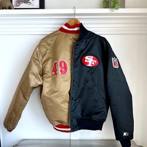 May include: A reversible satin bomber jacket with a gold side featuring the number "49" and a black side with the San Francisco 49ers logo and "NFL" patch.