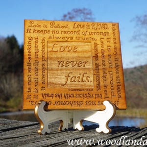 May include: A wooden plaque with a laser-engraved quote about love from 1 Corinthians 13:4-8. The plaque is on a small wooden stand. The quote reads: "Love is patient. Love is kind. It keeps no record of wrongs. It is not self-seeking. It is not easily angered. It always protects. It always trusts. It always hopes. It always perseveres. Love does not delight in evil. It is not proud. It does not envy. It does not boast. Love never fails."