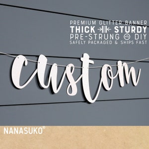 May include: A white glitter banner with the word "custom" in a cursive font, strung on a thin white string. The banner is against a gray background with the text "PREMIUM GLITTER BANNER" and "NANASUKO" at the bottom.