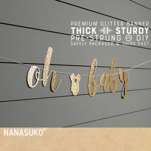 May include: Gold glitter banner that reads "Oh Baby" with a small baby onesie in the middle. The banner is pre-strung and comes with instructions for DIY assembly.  The banner is thick and sturdy, and is safely packaged and ships fast.  The banner is from the shop NANASUKO.