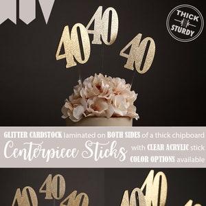 May include: Gold glitter cardstock '40' centerpieces with clear acrylic sticks. The cardstock is laminated on both sides of a thick chipboard.  The sticks are shown in a floral arrangement.