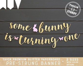 some bunny is turning one banner, 1st birthday banner, bunny theme, gold glitter party decorations, cursive banner, BUN003