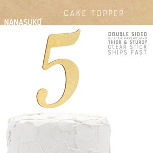 May include: Gold glitter paperboard cake topper in the shape of the number 5. The topper is double-sided and has a clear stick for easy placement on a cake.